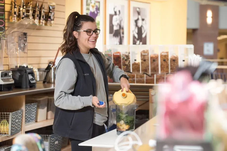 Server at Tuffy's Smoothie Bar prepares a smoothie for a customer